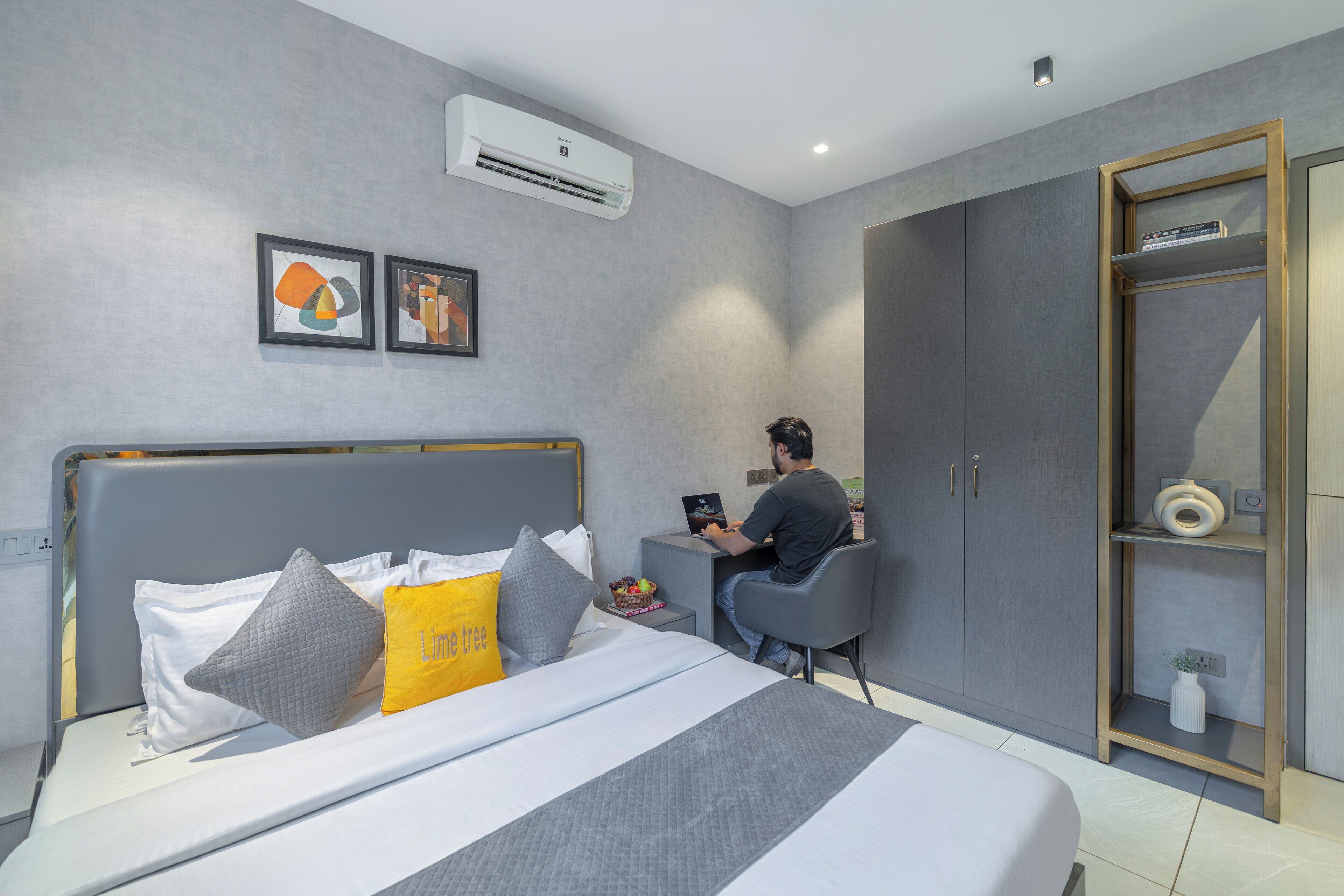 A modern bedroom with a bed, a desk, and a wardrobe.
