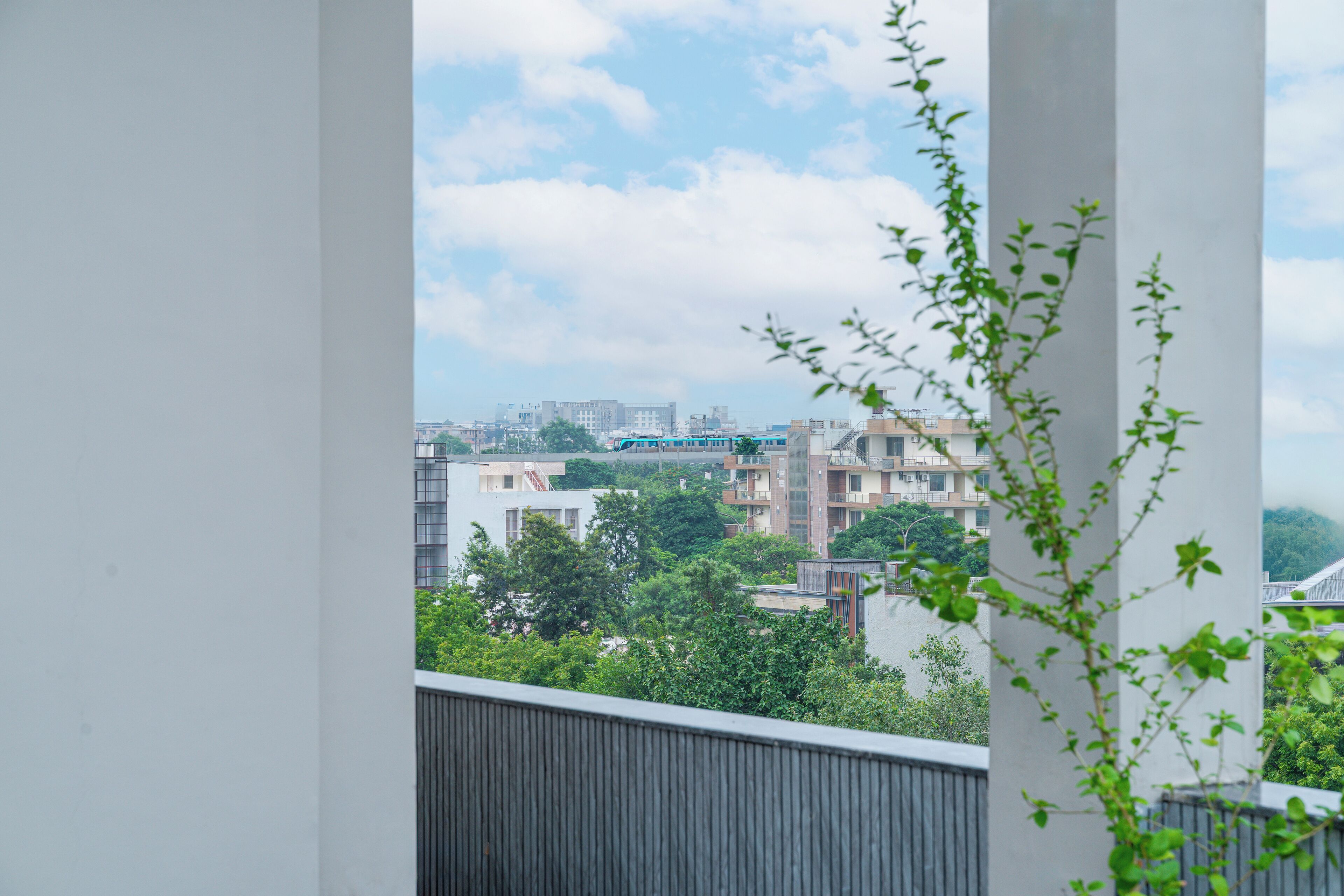 Un balcon offrant une vue sur le paysage urbain, avec des bâtiments et un pont situé au loin.