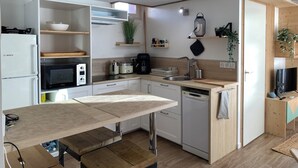 Eine moderne Küche mit weißen Geräten, einer Holz Arbeitsplatte und einem integrierten Geschirrspüler.