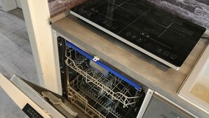 Ett kök med en inbyggd diskmaskin och en induktionshäll.
