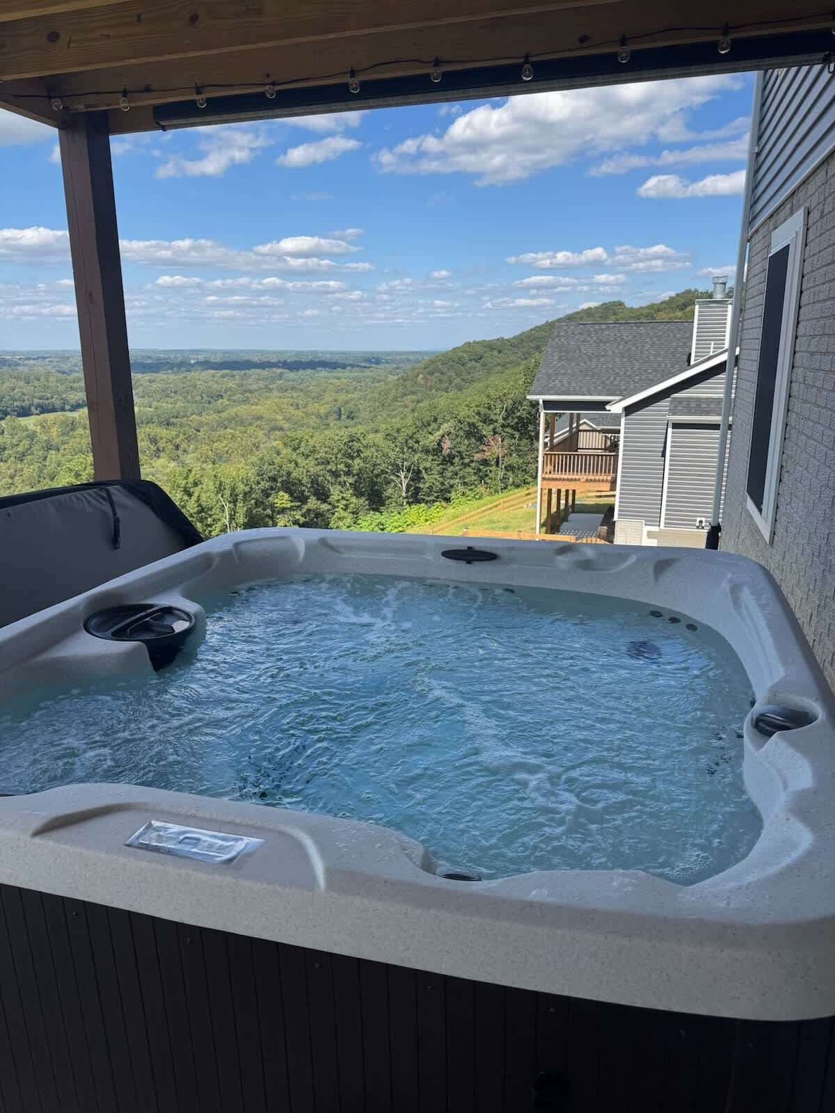 Ein Whirlpool mit Blick auf ein Haus und einen Wald.