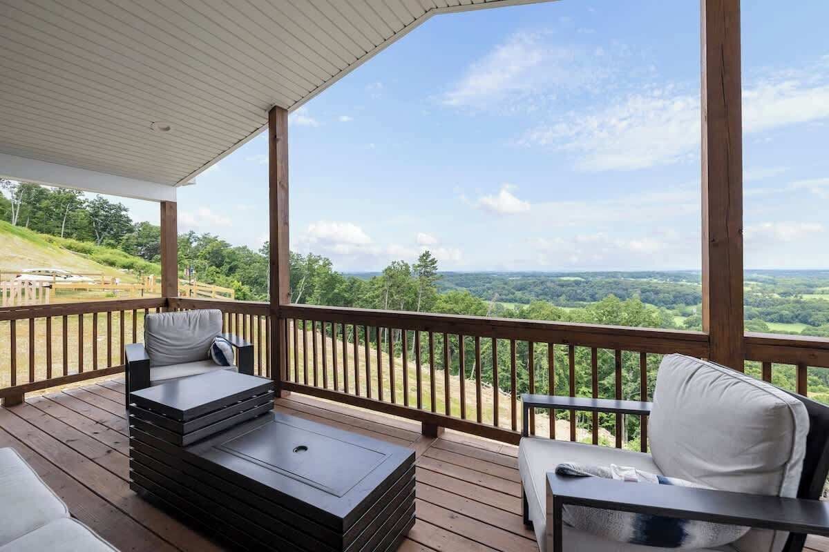 Eine überdachte Terrasse mit Blick auf eine hügelige Landschaft.