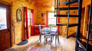 A wooden cabin interior with a dining table, chairs, a bunk bed, and a window with curtains. - Welcome to Fisherman's Dream, located near Hocking (McArthur)
