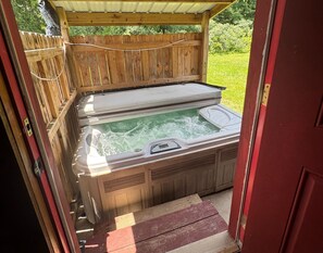 Ein Whirlpool mit Holzterrasse und Holzzaun im Hintergrund.