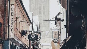 A narrow street with various shops and a large gothic building in the background.