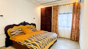 Een slaapkamer met een bed, gordijnen en een raam.