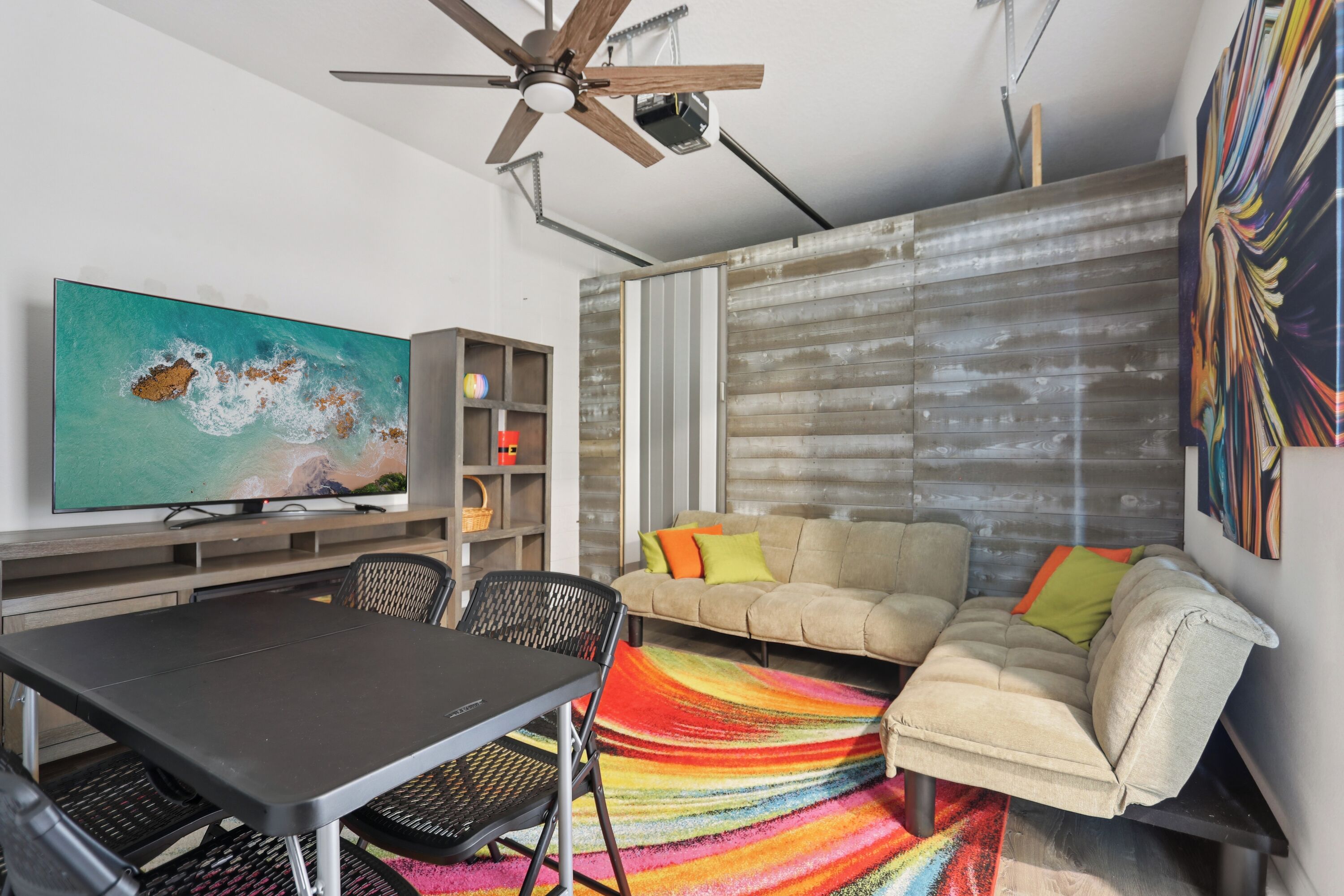 A modern living room with a sofa, a dining table, and a television.
