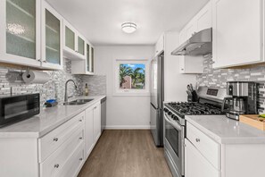 Galley kitchen with a coffee maker, microwave, and plenty of counter space