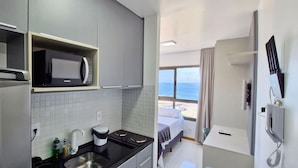 Una cocina moderna con microondas, cafetera y vista al océano.
