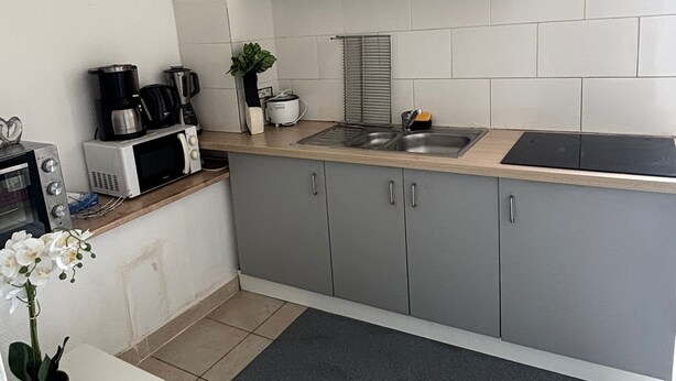 A compact kitchen with white cabinets, a microwave, a toaster, and a sink. - Room Notre-Dame de Paris, 20 minutes from Paris SHARED APARTMENT (Épinay-sur-Seine)