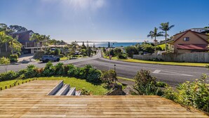 A residential street with houses, a wooden deck, and a clear view of the ocean. - Doubtless Bay Vista - Cable Bay Retreat (Cable Bay)