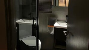 A modern bathroom with a bathtub, toilet, and sink.