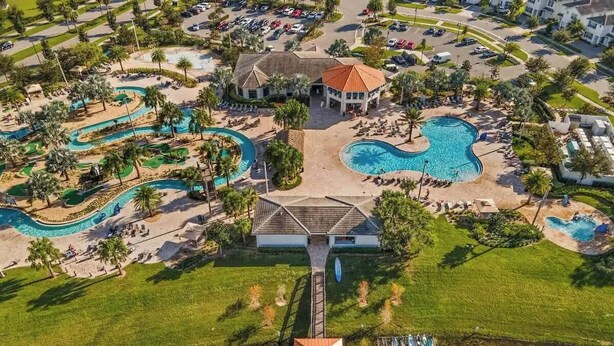 Vista aérea de un complejo turístico con varias piscinas, un edificio central y zonas ajardinadas circundantes.