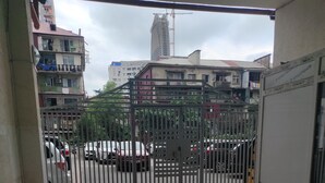 A gated entrance with a tiled floor, a metal gate, and a view of parked cars and buildings in the background. - zura (Batumi)