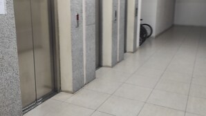 A hallway with a row of elevators and a bicycle parked against the wall. - zura (Batumi)