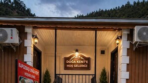 Entrada de un hotel con un cartel que dice 'DOGA KENT' HOŞ GELDİNİZ y una escalera que conduce a la entrada.