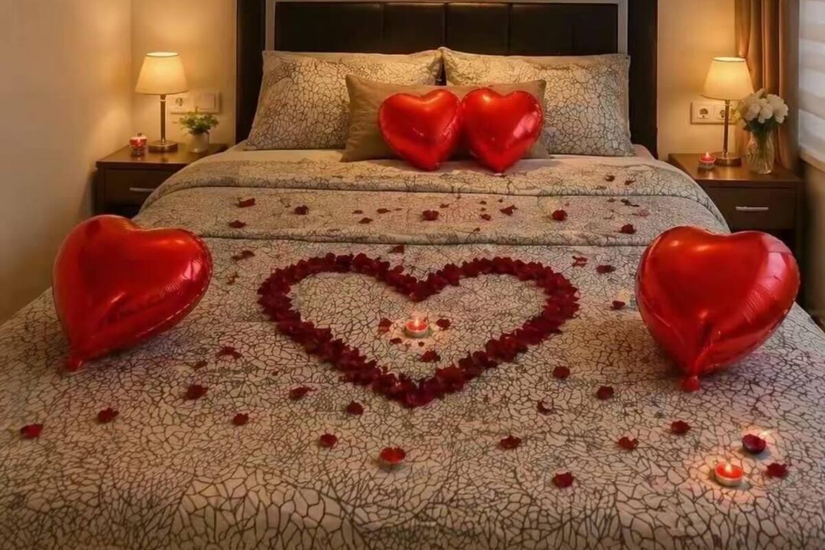 Un dormitorio con cama, decoraciones con forma de corazón y un candelabro.