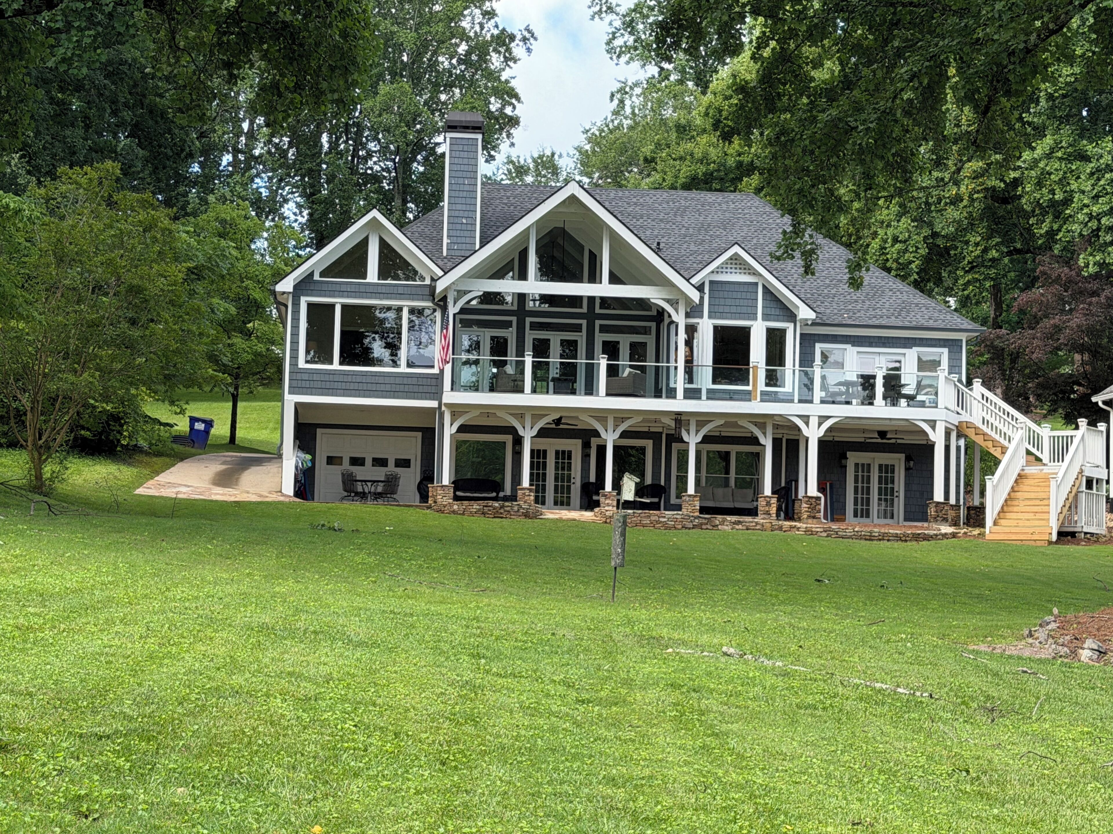 A two-story house with a large front porch, a garage, and a staircase leading to an upper level.
