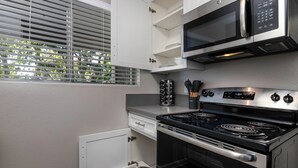 A kitchen with a stove, microwave, and cabinets. - Peaceful King Suite near FSAC & Proactive Sports w/ Gym Access & 1 Gig WiFi (Thousand Oaks)