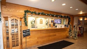 A reception desk with a sign for bike locker rentals, wooden cabinetry, and a Christmas tree. - 372 Mountain Lodge Ski/Bike/Hike In & Out (Snowshoe)