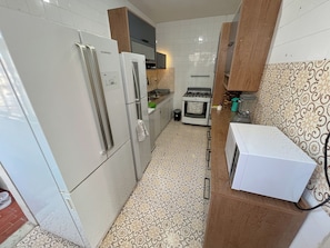 Chambre Triple, vue plage | Cuisine partagée | Réfrigérateur dans l'espace commun, micro-ondes dans l'espace commun