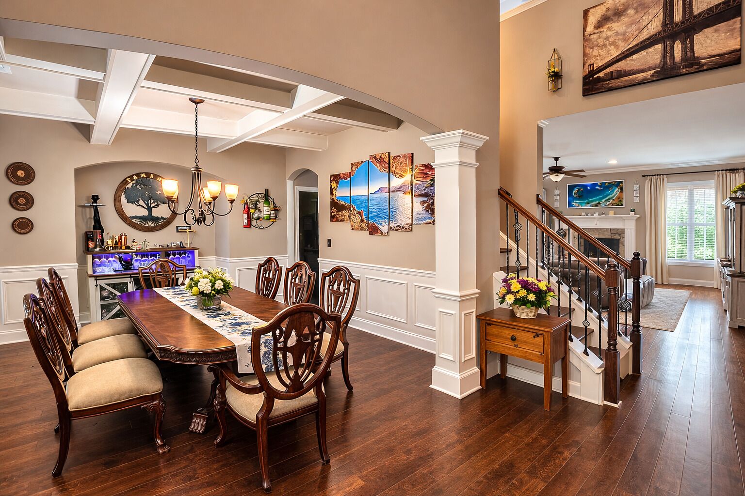 A dining area with a long wooden table, multiple chairs, and a chandelier.