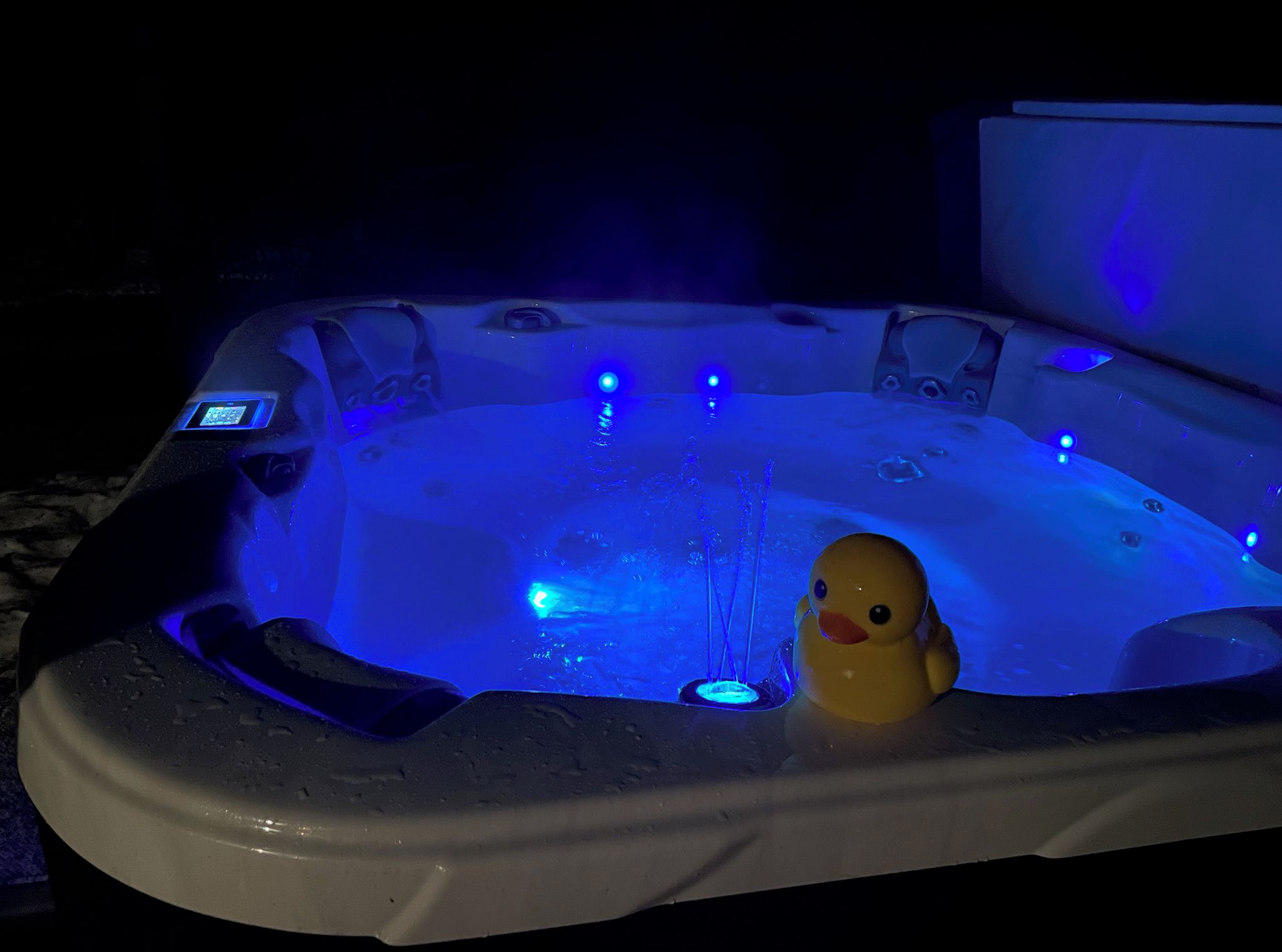 A hot tub with a duck toy and blue LED lights.