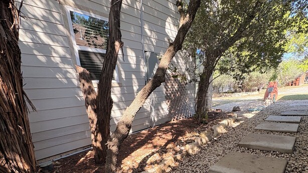 A pathway with stepping stones leading to a house with a white exterior and a tree in the foreground. - Cozy Casita in San Antonio Close to sea world- downtown-fiesta Texas-Alamo ranch (San Antonio)
