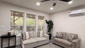 A living room with two sofas, a ceiling fan, and a potted plant. - Cozy Casita in San Antonio Close to sea world- downtown-fiesta Texas-Alamo ranch (San Antonio)