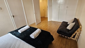 Quarto com cama, sofá e guarda-roupa.