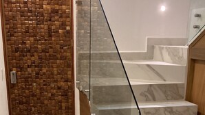 A staircase with glass railings and marble steps.