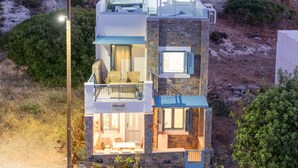 A multi-level modern house with a balcony, a dining area, and a visible kitchen. - New Seafront Villa with Rooftop Hot Tub, 50 m from the Beach (Mochlos)