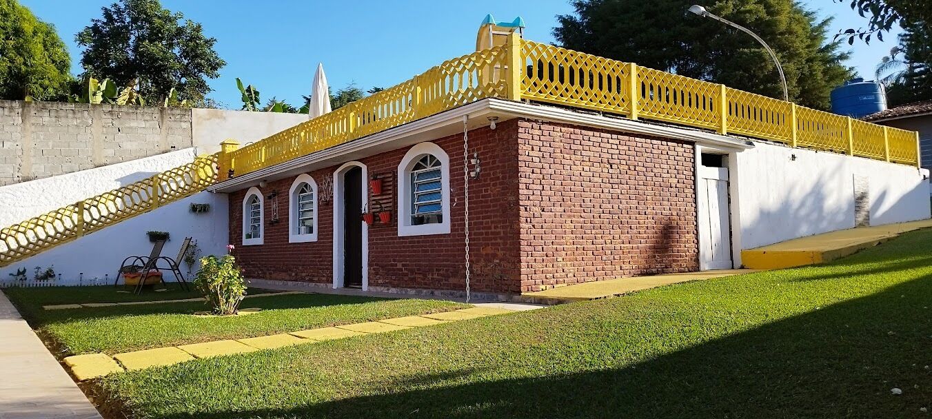 A brick building with a yellow lattice roof and a white exterior wall.