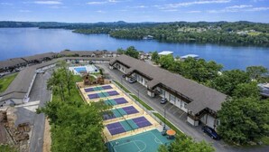 Hotel frente a un lago con canchas de tenis, piscina y estacionamiento.