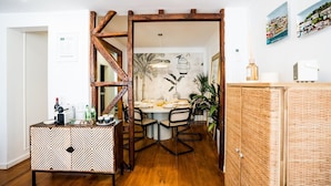 A dining area with a wooden trestle, a patterned cabinet, and a wicker cabinet.