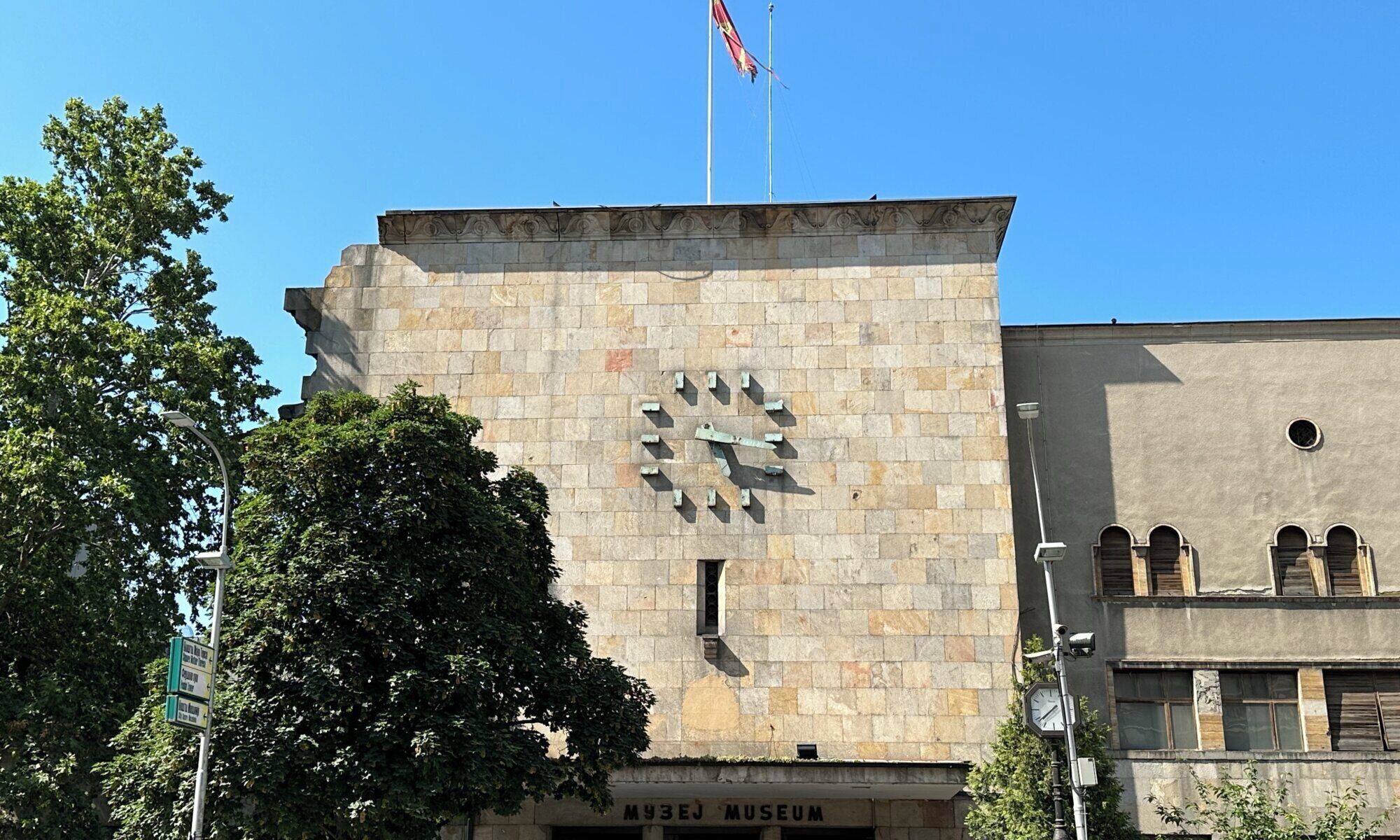 A building with a clock and a flag on top.