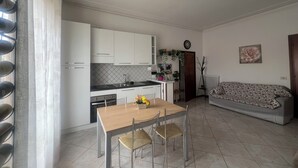 Un espace de vie compact comprenant une cuisine, un coin repas et un canapé.