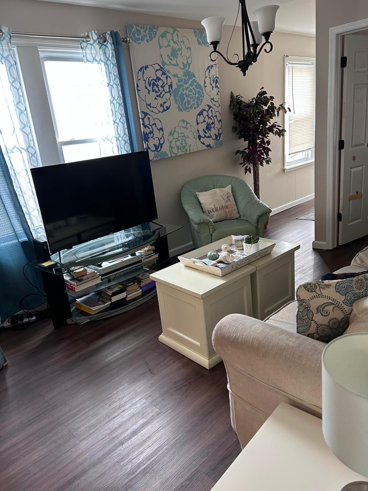Una sala de estar con televisor de pantalla plana, una estantería, una mesa de centro y un sofá.