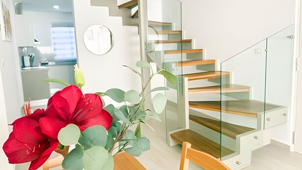A modern interior with a staircase featuring glass railings and wooden steps. - Condo with Rooftop steps from the beach! (Punta Cana)