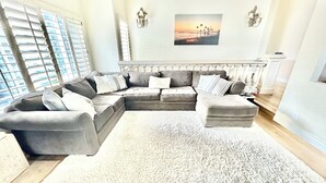 A modern living room with a sectional sofa, a large area rug, and a painting on the wall. - Big 4-bedroom House close to Beach in San Clemente (San Clemente)