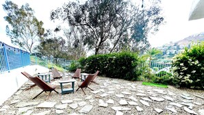 An outdoor seating area with stone flooring and wooden furniture. - Big 4-bedroom House close to Beach in San Clemente (San Clemente)