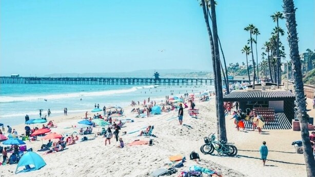 A beach with people, umbrellas, and a pier in the background. - Big 4-bedroom House close to Beach in San Clemente (San Clemente)