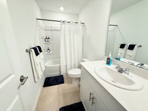 Ein modernes Badezimmer mit Badewanne, Toilette und Waschbecken.