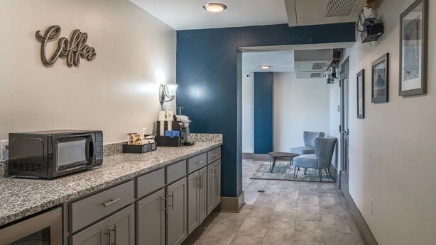 A kitchen with a microwave, coffee bar, and a dining area with a chair and table. - 2-bedroom apartment in Midtown Memphis with AC, fitness room (Memphis)