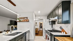 Una cocina moderna con una isla central, electrodomésticos integrados y encimera de madera.