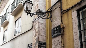 Una señal de calle que indica Rua da Judaria y un poste de luz en la fachada de un edificio.