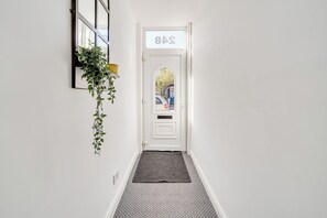 A hallway with a white door marked "8A" and a small rug on the floor.