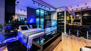 A modern hotel room with a bed, a TV, a bar area, and a kitchen. - Perfect apartment in the best building on the waterfront with an unobstructed view of the incredible sea! (José Menino Santos)