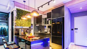 A modern kitchen with a central island, pendant lighting, and a green wall. - Perfect apartment in the best building on the waterfront with an unobstructed view of the incredible sea! (José Menino Santos)