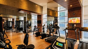 A gym with exercise equipment, a treadmill, and a TV screen. - Perfect apartment in the best building on the waterfront with an unobstructed view of the incredible sea! (José Menino Santos)